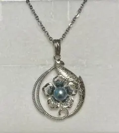 花と葉のモチーフ、真珠があしらわれたシルバーのネックレス。