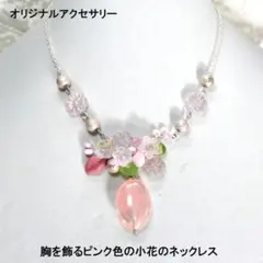 胸を飾るピンク色の小花のネックレス
