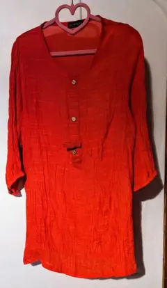 オレンジ色のボタン付き長袖トップス