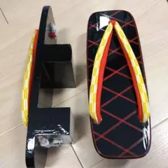 新品未使用 伝統的な木製下駄 黒塗りに赤の模様 鼻緒が黄色と朱赤の二本