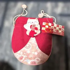 猫の飾り付き赤い巾着袋