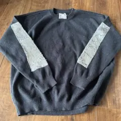 黒のニットセーター 袖に装飾あり