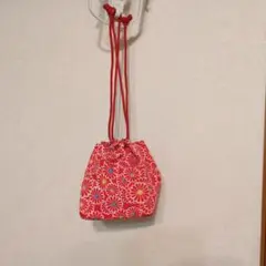 赤い花柄の巾着型和装用バッグ