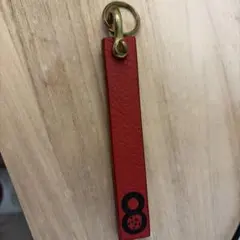 真鍮製の金具が付いた赤いキーリング