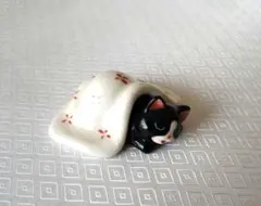 布団に入る眠そうなハチワレ猫 陶器製 置物