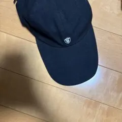 つば長すぎた黒いキャップ 55の盾型ロゴ付き