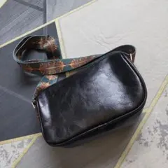 黒のショルダーバッグ 装飾的ストラップ付き