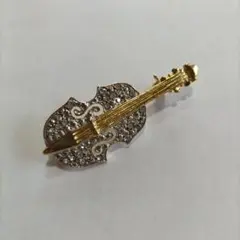 Brooch featuring a violin, cello, viola, double bass, and other stringed instruments.