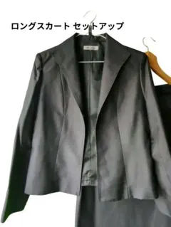 黒のジャケットとロングスカートのセットアップ