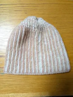 手編みのニット帽子、淡いピンクと白のストライプ