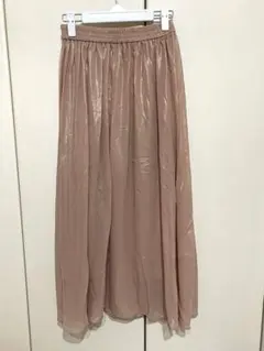 アラマンダのスモークピンクの艶やかな光沢を放つ箔プリントのロング丈のスカート