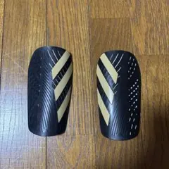 adidas シンガード ブラック/ゴールド