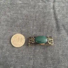 緑色の石の金色ブローチ