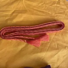 オレンジ色の房付き帯飾り