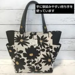 生成り色地黒色の花柄の両サイドポケット付きトートバッグ