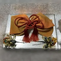 オレンジ色リボン型髪飾り 花飾り付き