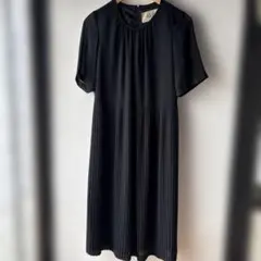 黒のプリーツワンピースとジャケット