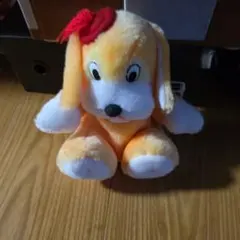 オレンジ色リボン付き犬のぬいぐるみ