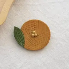 オレンジのお花ブローチ　ハンドメイド　陶器風　北欧　ナチュラル　ギフト