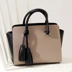 ベージュと黒のタッセル付きハンドバッグ