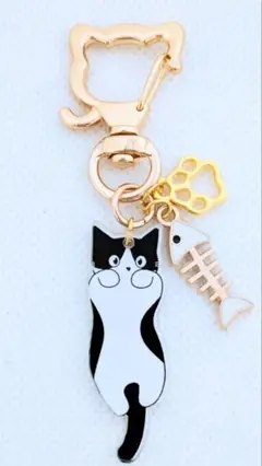白色の魚の骨とのびのびへそ天する黒ハチワレの猫キーホルダー