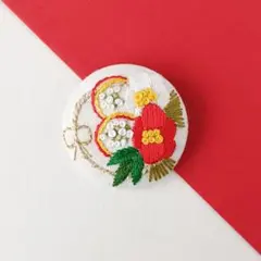 紅白ツバキのお正月しめ縄飾り刺繍ブローチ　ハンドメイド　くるみボタン
