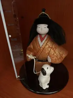 オレンジ着物の人形と犬の置物