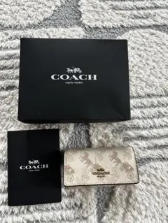 新品カード保存袋付きコーチCOACHスヌーピーキーケース SV/KHaki本物