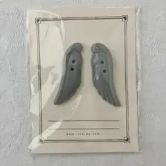 【co- （コー ）】グレーの翼型 ボタン 羽