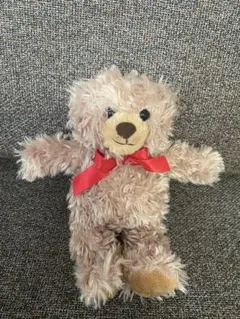 ベージュのクマのぬいぐるみ 赤いリボン付き