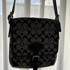 Coach のショルダーバッグ 黒とベージュのロゴパターン