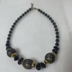 装飾的な模様の黒と金色のネックレス