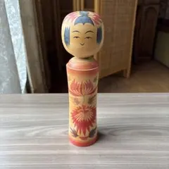 伝統的なこけし 木製人形 赤と黄色の花模様