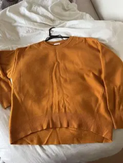 オレンジ色の長袖ニット