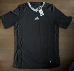 新品、adidas製のブラック2XL審判用シャツ、2つの胸ポケット付き。
