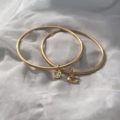 coachゴールドバングル 2つのチャーム付き