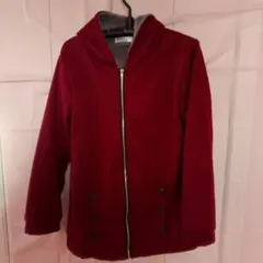 フード付きのエンジ色のジッパー式裏ボアジャンパー、ボタン付きポケット付き。