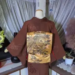 地紋が煌めく飴色の地に、墨色の絵模様が迫力ある、正絹アンティークの昼夜帯です