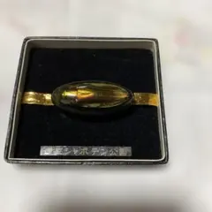 オーバル型金色と黒色の帯留め