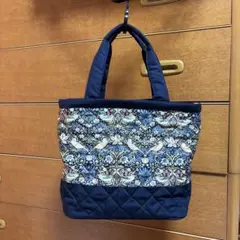 花と鳥のプリントが特徴的なネイビーのトートバッグ