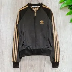 アディダス ウィメンズファイヤーバード裏地総柄 ジャケット ゴールド黒 S