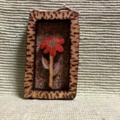 額に入った小さな木のピンブローチ