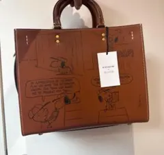 COACH X PEANUTSローグ バッグ・ニュースペーパー プリントブラウン
