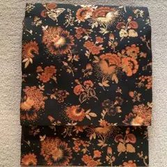 九寸名古屋帯 六通　黒地に洋花　オレンジ色にゴールドを効かせたおしゃれな帯。