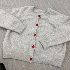 グレーのカーディガン 赤いボタン付き