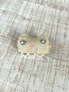猫の形状のベージュブローチ
