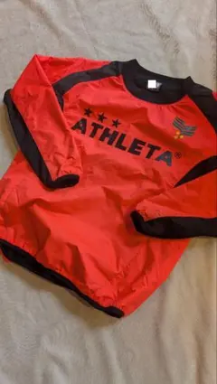 ATHLETA ピステ・ウィンドブレーカー オレンジ/ブラック　記名有り