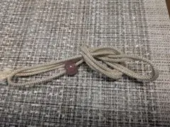 ベージュの帯締め 紫色の飾り玉付き