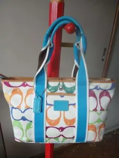 コーチの、やや大ぶり軽量大収納バッグ、カラフルC柄布地と青牛革