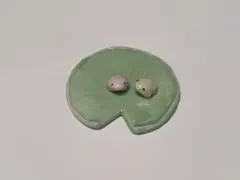 緑色の睡蓮の葉とカエルの置物